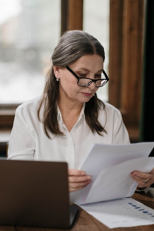 Older woman sorting through bills.
